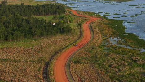 A-scenic-dirt-road-running-alongside-a-tributary-of-the-Paraná-River,-creating-a-picturesque-view-in-Argentina