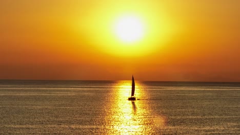 Erstaunlicher-Blick-Auf-Die-Goldene-Sonne,-Die-Ein-Kleines-Segelboot-Einholt