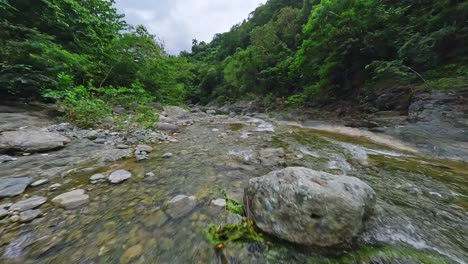 Drone-FPV-over-transparent-water-of-river-flowing-in-wilderness-landscape,-Las-Yayitas-Dominican-Republic