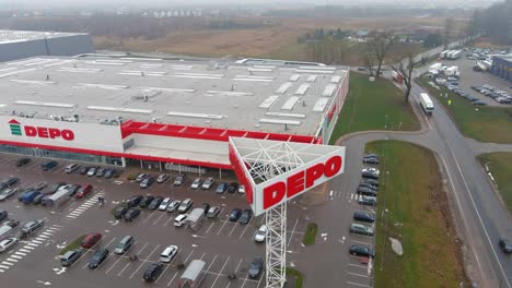 Depo-store-in-Lithuania-with-massive-logo,-aerial-descend-view