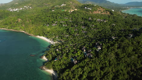 Vacation-houses-in-the-mountains-of-Koh-Samui-Island-in-Thailand-at-sunset,-aerial-orbital