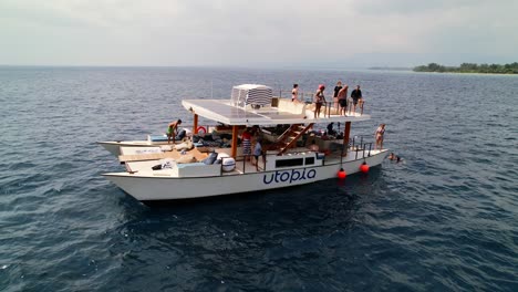 Mann-Springt-Von-Moderner-Katamaran-Yacht-Ins-Meer-Rund-Um-Die-Insel-Gili-In-Indonesien---Freizeitbeschäftigung-Für-Wohlhabende-Menschen