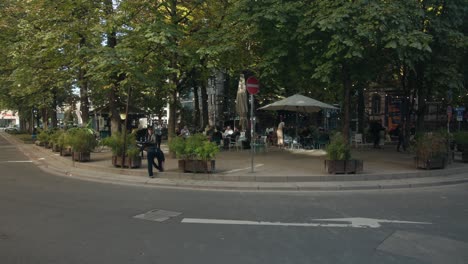 Pan-across-calm-outdoor-cafe-garden-area-at-golden-hour-in-the-shade-of-busy-city-buildings