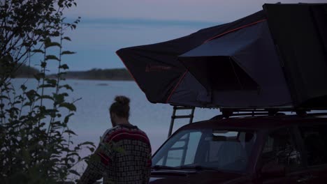 Eine-Person-Mit-Einem-Dachgepäckträger-Zeltet-Während-Des-Sonnenuntergangs-Am-Meeresufer