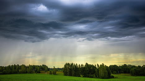 Es-Ist-Faszinierend-Zu-Beobachten,-Wie-Regenwolken-Aus-Der-Zeitrafferperspektive-Anmutig-über-Ein-Tal-Mit-üppigen-Grünen-Feldern-Gleiten