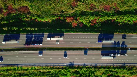 Aerial-view-of-highway,-trucks,-autumn-trees