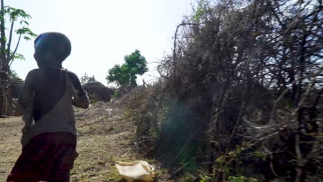 Pobre-Niña-Africana-Con-Ropa-Rota-Caminando-A-Lo-Largo-De-La-Valla-En-El-Pueblo