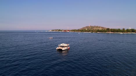 Katamaran-Yachtschiff-Kreuzt-In-Der-Nähe-Der-Küste-Der-Insel-Gili-In-Lombok,-Indonesien---Überflug-Aus-Der-Luft