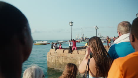 Harbor-scene-with-people-watching-cliff-diving