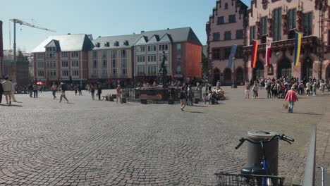 Static-wide-angle-view-of-bustling-Romerberg-Market-square-at-midday