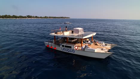 Wealthy-Woman-Traveler-Cruising-on-Utopia-Catamaran-Yacht-Tour-Near-Gili-Islands-in-Indonesia