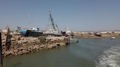 The-Banks-Of-Gilao-River-In-Santa-Maria,-Portugal---Pullback-from-Shipyard---Aerial