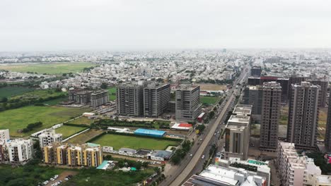 Aerial-drone-camera-hovering-over-Rajkot-city-showing-airport-and-high-rise-buildings