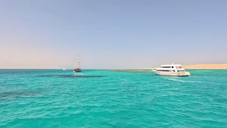 Eine-Fregatte-Und-Eine-Yacht-Im-Türkisfarbenen-Wasser-Jenseits-Der-Dünen-Ägyptens