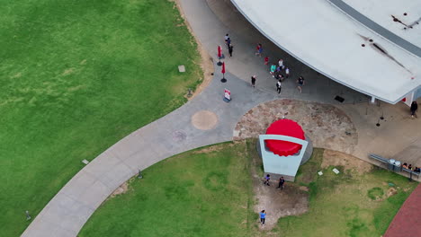 High-angle-view-of-large-red-bottle-crown-cap-and-opener-in-front-of-museum