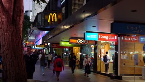People-shopping-and-dinning-at-bustling-downtown-Queen-street-mall-at-night,-static-shot-at-Brisbane-city,-Queensland
