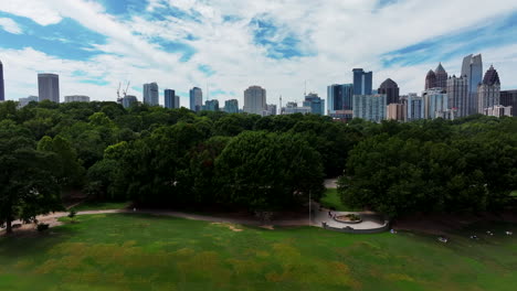 Aerial-slider-of-trees-in-city-park,-people-relaxing-in-shadow