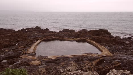 Wide-shot-at-Low-level-shot-of-Mousehole-Rock-Pool-tidal-swim-pool,-Cornwall