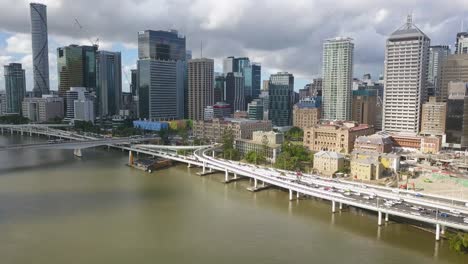 Aerial-flying-backwards-from-Brisbane-River,-CBD-in-background,-Brisbane,-Australia