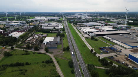 Commercial-district-of-city-with-wind-turbines,-aerial-drone-view