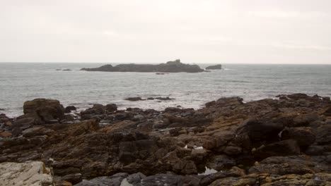 Low-level-shot-of-St-Clement's-Isle-with-rock-in-foreground,-Cornwall