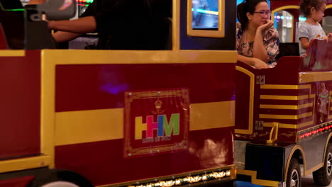 Children-enjoying-a-kiddie-train-ride-with-their-parents-inside-the-amusement-section-of-a-mall-in-Pattaya,-Thailand