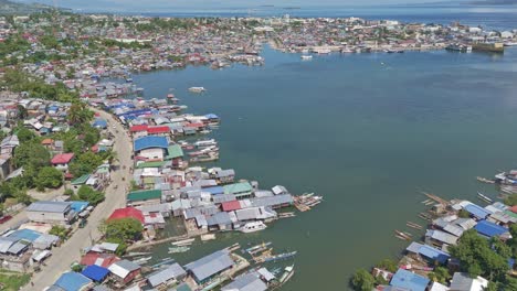 Harbor-crowded-with-houses-of-illegal-settlers-in-Surigao-city,-Mindanao,-Philippines,-aerial-dynamic