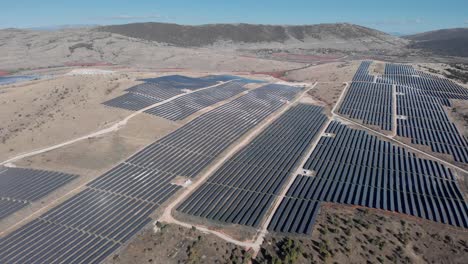 Drone-Revelador-Sobre-Mega-Parque-De-Energía-Solar-Paneles-De-Fila-De-Granja-Verano-Rural-Soleado