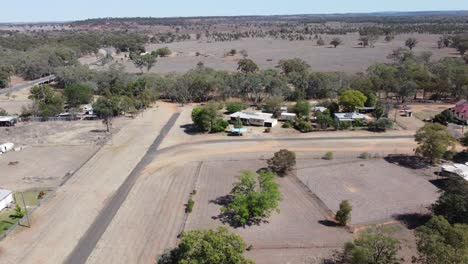 Drohne-Fliegt-über-Eine-Sehr-Kleine-Landstadt-Im-Australischen-Outback-In-Richtung-Einer-Hauptstraße