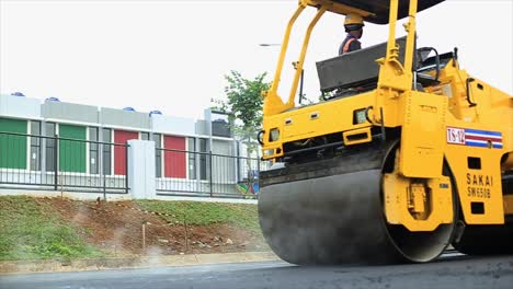 Los-Trabajadores-Compactan-El-Asfalto-Utilizando-Una-Máquina-Laminadora,-Un-Rodillo-Tándem,-Que-Es-Un-Tipo-De-Vehículo-De-Construcción-Compactador-Pesado-Utilizado-Para-Nivelar-Tierra,-Grava,-Hormigón-O-Asfalto-En-La-Construcción-De-Carreteras.