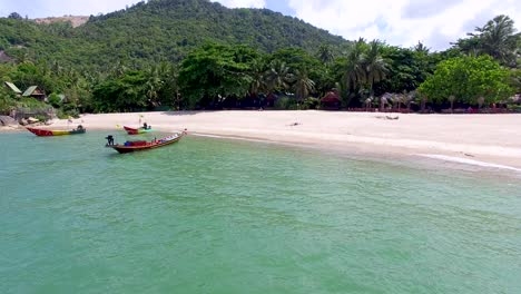 Panning-from-right-to-left,-while-taking-an-aerial-drone-shot-of-Haad-Than-Sadet-Beach-located-Koh-Phangan-island-in-the-south-of-Thailand