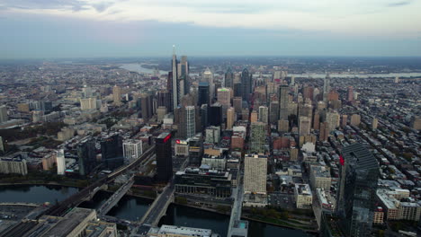 Aerial-view-rotating-away-from-the-skyline-of-Philadelphia,-sunset-in-PA,-USA