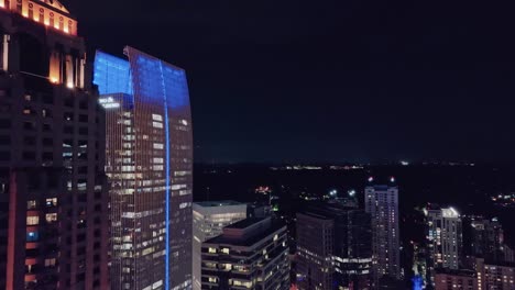 Vuelo-Aéreo-Entre-El-Rascacielos-De-La-Torre-Sinfónica-De-Iluminación-En-El-Centro-De-Atlanta-Por-La-Noche