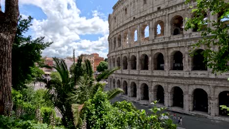 Seeing-The-Exterior-Walls-Of-The-Colosseum-From-Via-Nicola-Salvi-With-Lush-Green-Plants-Trees-In-View-On-Sunny-Day-In-Rome