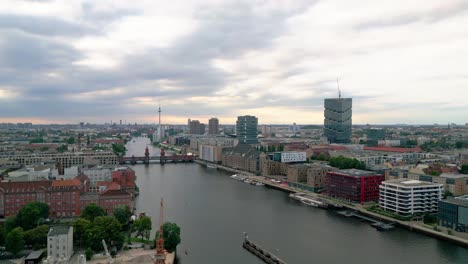 Erleben-Sie-Berlins-Faszination-Aus-Der-Luft,-Während-Eine-Drohne-Anmutig-über-Die-Spree-Gleitet-Und-Dabei-Die-Berühmte-Oberbaumbrücke-Und-Die-Faszinierende-Skyline-Der-Stadt-Einrahmt