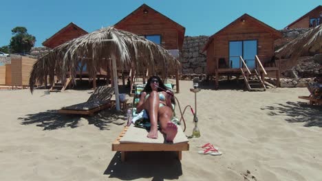 A-woman-smoking-Shisha-while-sunbathing-on-the-beach