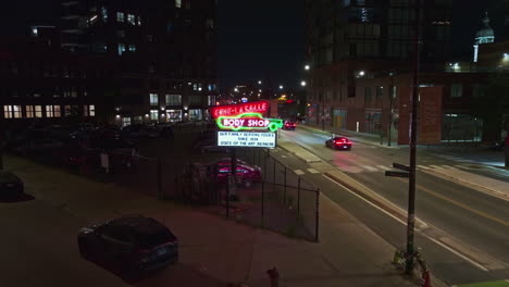 Aerial-view-toward-the-Erie-Lasalle-Body-Shop-sign,-night-in-River-West,-Chicago,-USA