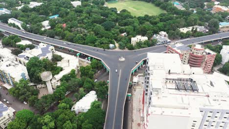 Luftaufnahme-Der-Stadt-Rajkot-Mit-Überführungsbrücke,-Die-Drei-Nebenstraßen-Verbindet-Und-Den-Verkehr-Reduziert,-Hochhäuser,-Gärten-Und-Sonnenkollektoren