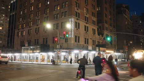 Warwick-hotel-sign-lines-building-at-night-as-tourists-walk-past