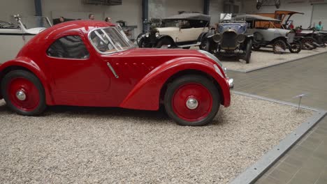 Red-vintage-car-at-exhibition-of-historic-automobiles,-offering-a-captivating-display-of-classic-cars-from-different-eras-in-National-Technical-Museum-in-Prague,-Czech-Republic