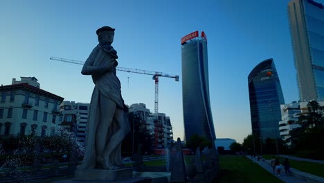 Brunnen-Der-Vier-Jahreszeiten-Am-Julius-Caesar-Platz-Mit-Blick-Auf-Das-Stadtleben-Und-Die-Einkaufs--Und-Geschäftsviertel-Tre-Torri,-Mailand,-Italien