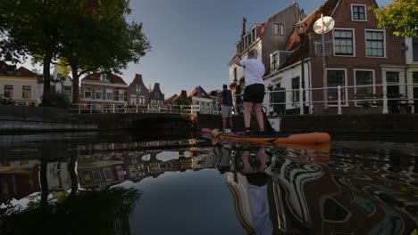 A-man-and-a-woman-enjoying-paddle-boarding-on-the-canals-in-Haarlem-city-centre