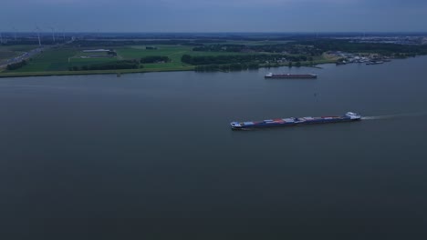 Light-fades-over-Moerdijk-as-Cargo-ship,-Olesia-sails-towards-it’s-next-destination