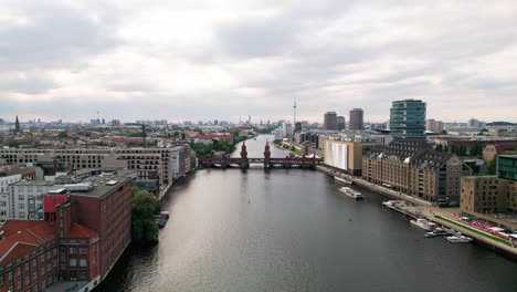 Experience-Berlin's-allure-from-the-skies-as-a-drone-gracefully-glides-over-the-Spree-River,-framing-the-iconic-Oberbaum-Bridge-and-the-captivating-city-skyline