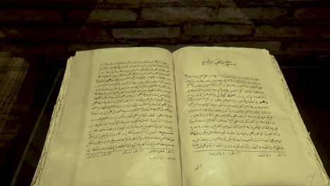 Libro-Antiguo-Sobre-Medicina-De-La-Edad-De-Oro-Islámica-Con-Páginas-Abiertas-En-Exhibición-En-El-Museo-De-Eruditos,-Khiva,-Uzbekistán