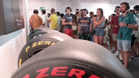 Visitors-and-Formula-1-fans-look-at-Pirelli-F1-racing-tyres-displayed-during-the-world's-first-official-Formula-1-exhibition-at-IFEMA-Madrid,-Spain