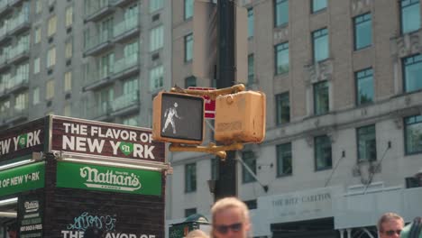 Red-stop-hand-at-crosswalk-changes-to-green-walking-man,-cityscape-iconic-scene