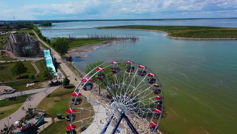 Drone-shot-over-a-ferris-wheel-at-a-theme-park,-sunny,-summer-day-in-Milwaukee,-USA