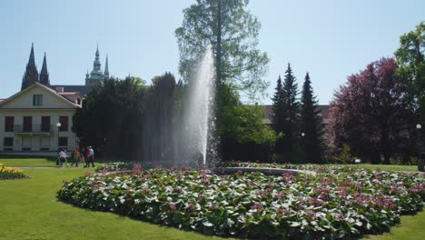 Gente-Caminando-Bajo-La-Fuente-En-El-Jardín-Del-Castillo-De-Praga-En-Un-Día-Soleado-En-Praga,-República-Checa