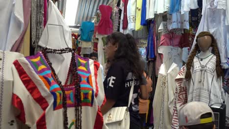 Toma-En-Cámara-Lenta-De-Personas-Mirando-La-Ropa-A-La-Venta-En-Un-Mercado-Callejero-Mexicano